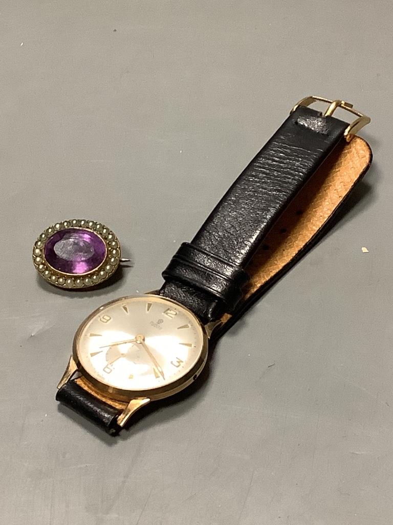 A gentleman's 1960's 9ct gold Tudor manual wind wrist watch, on a leather strap (lacking winding crown), with case back inscription, together with a Victorian gilt metal, amethyst and seed pearl brooch, 22mm.